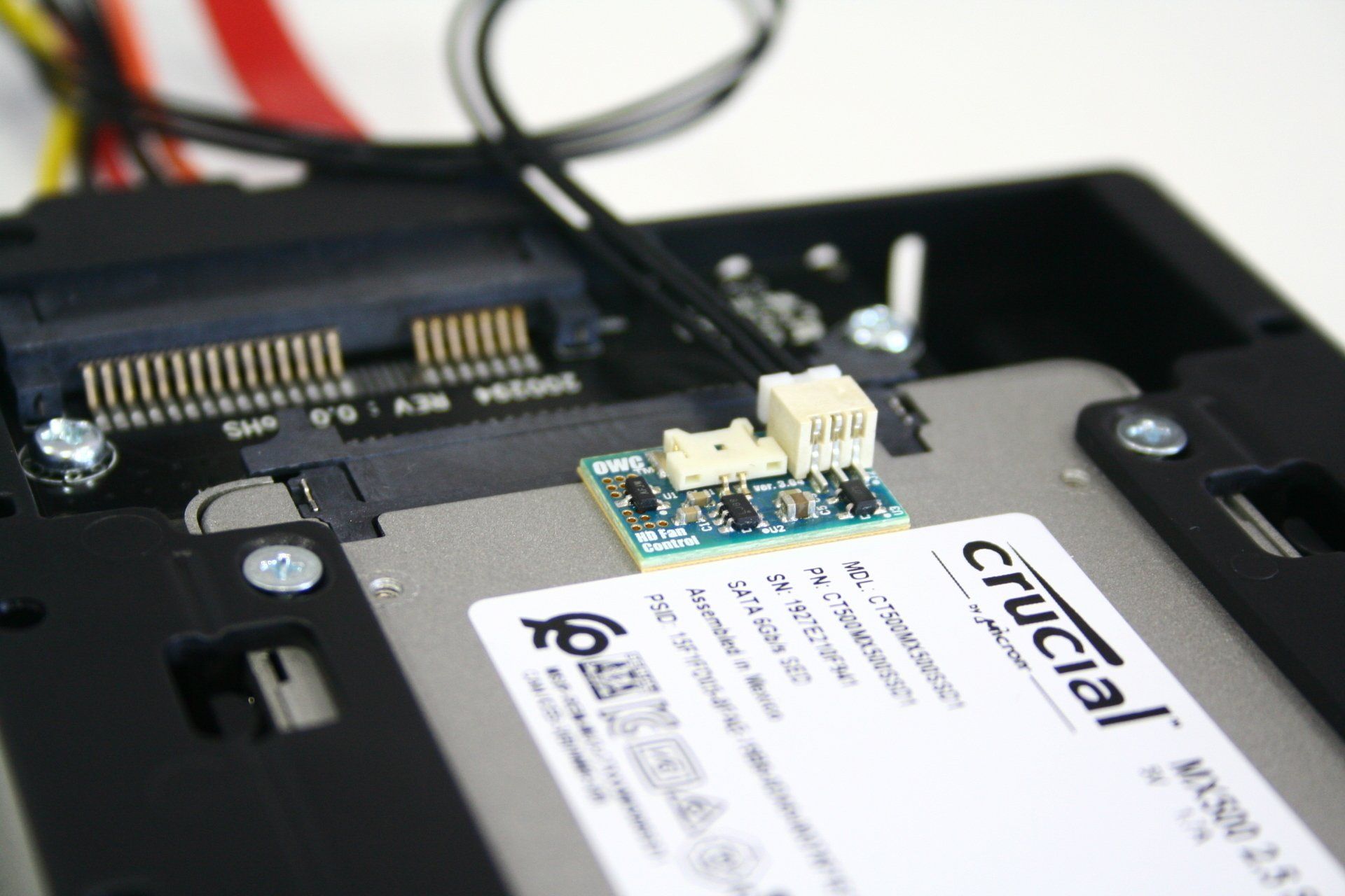 A crucial Solid State drive has a special thermal monitor installed on it in a caddy.