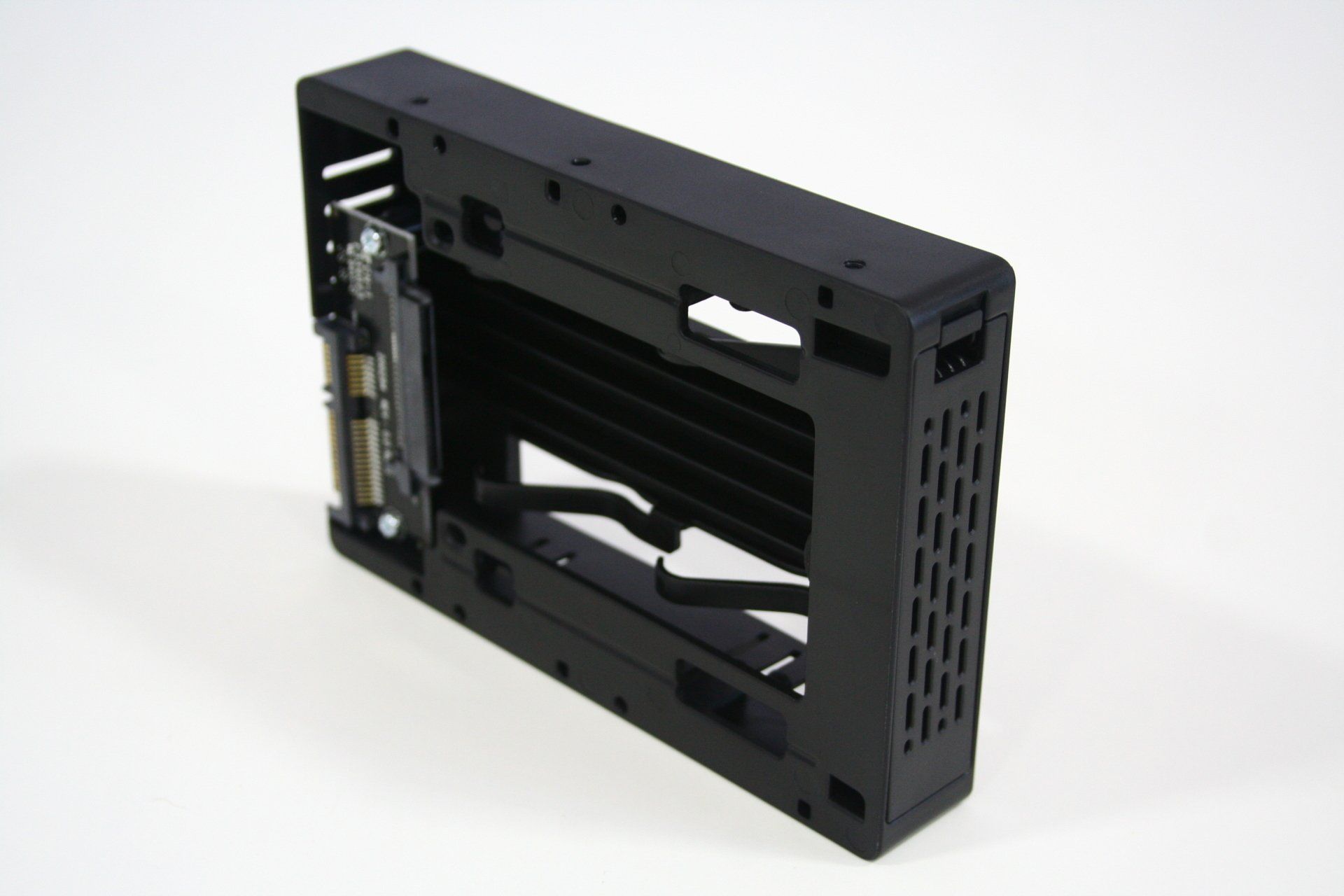 A black caddy with holes in it is sitting on a white surface