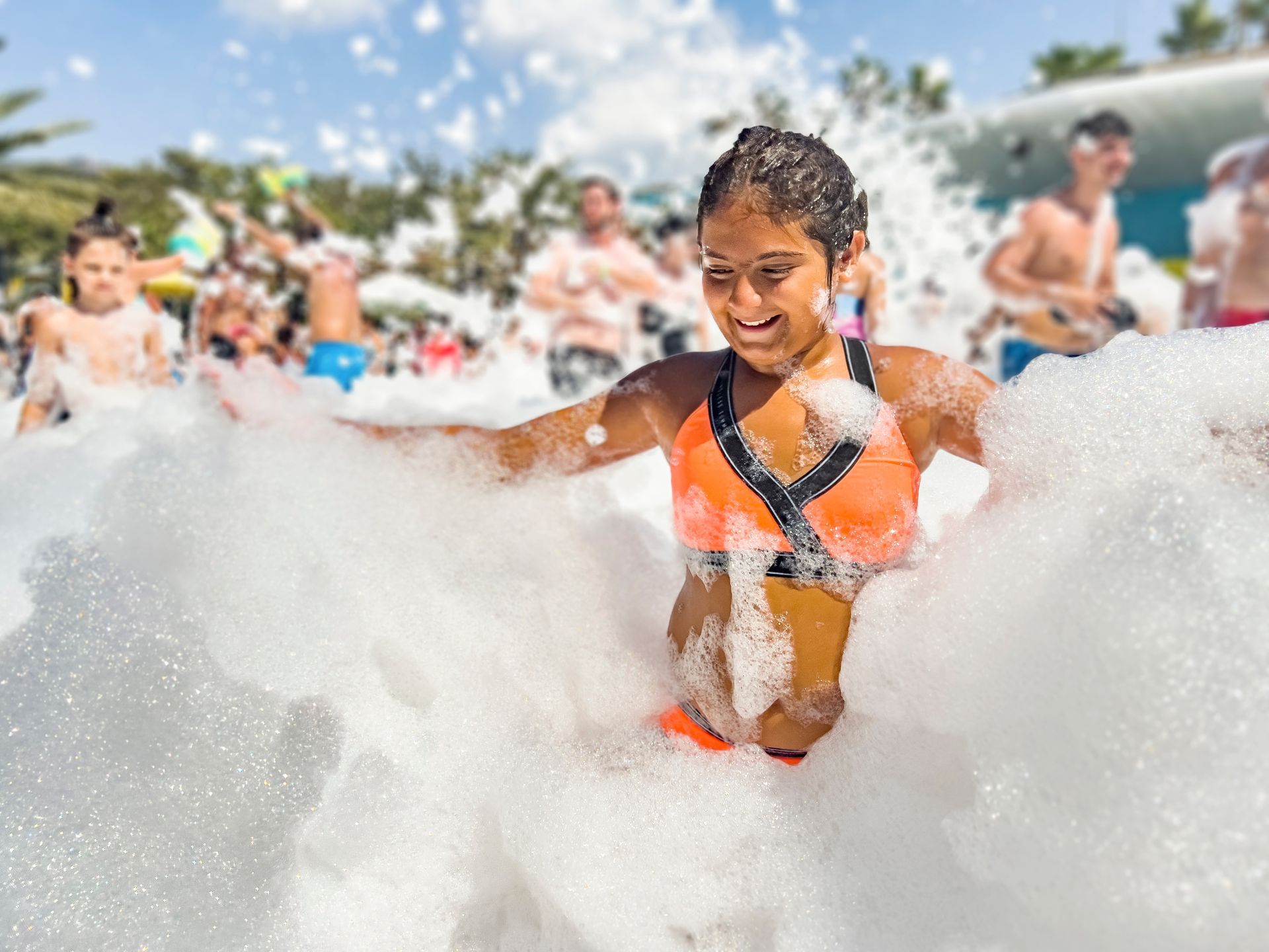 A young girl is playing in a pool of foam.