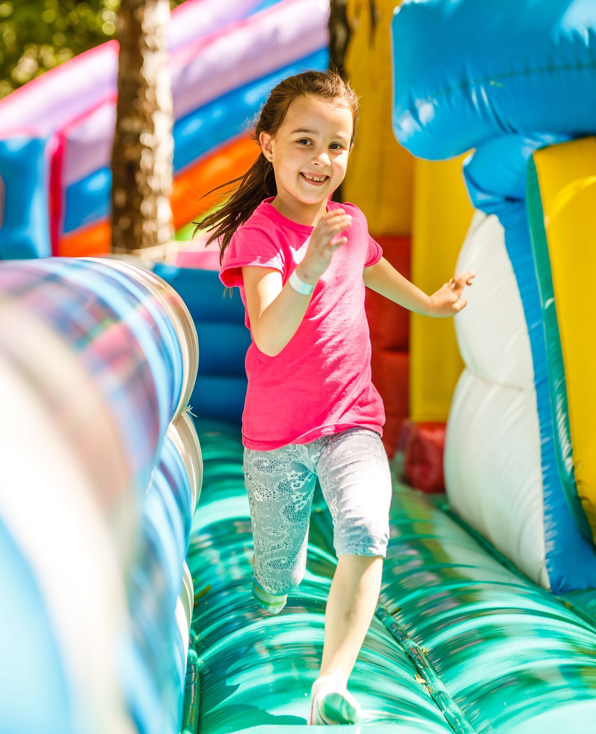 A little girl is playing on a bouncy house. A little girl is playing on a bouncy house.