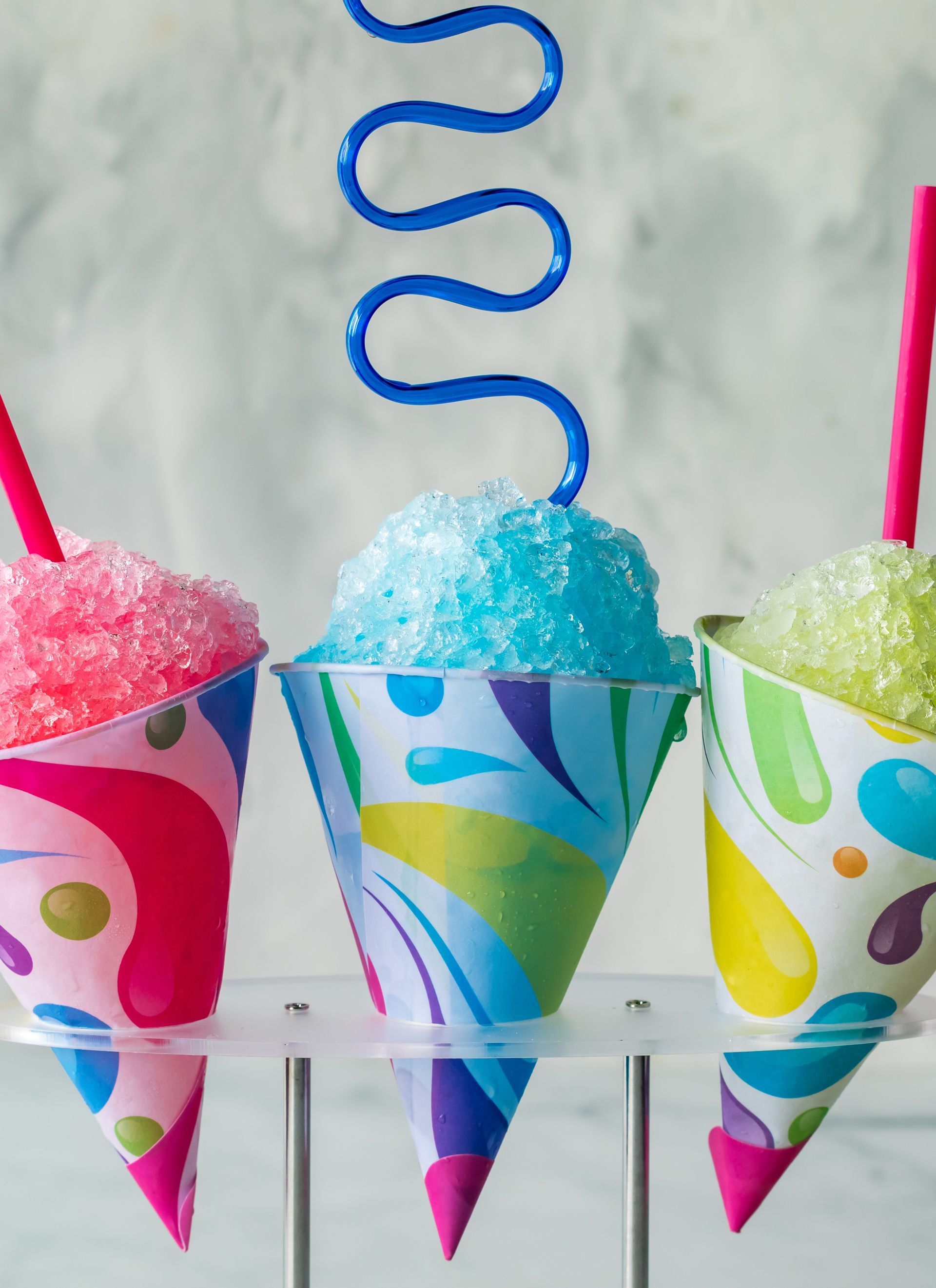 Three cups of shaved ice with straws in them. Three cups of shaved ice with straws in them.