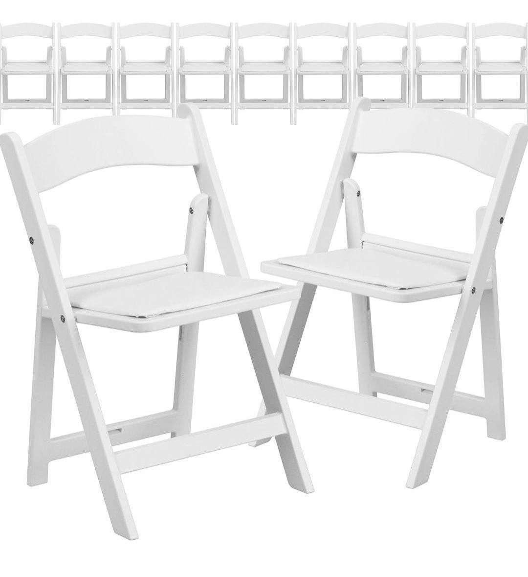 Two white folding chairs.