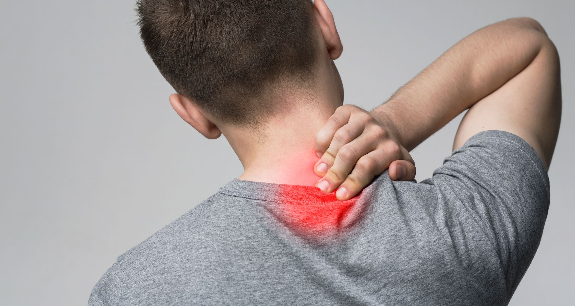 Person holding the back of the neck, highlighting an area of pain in red