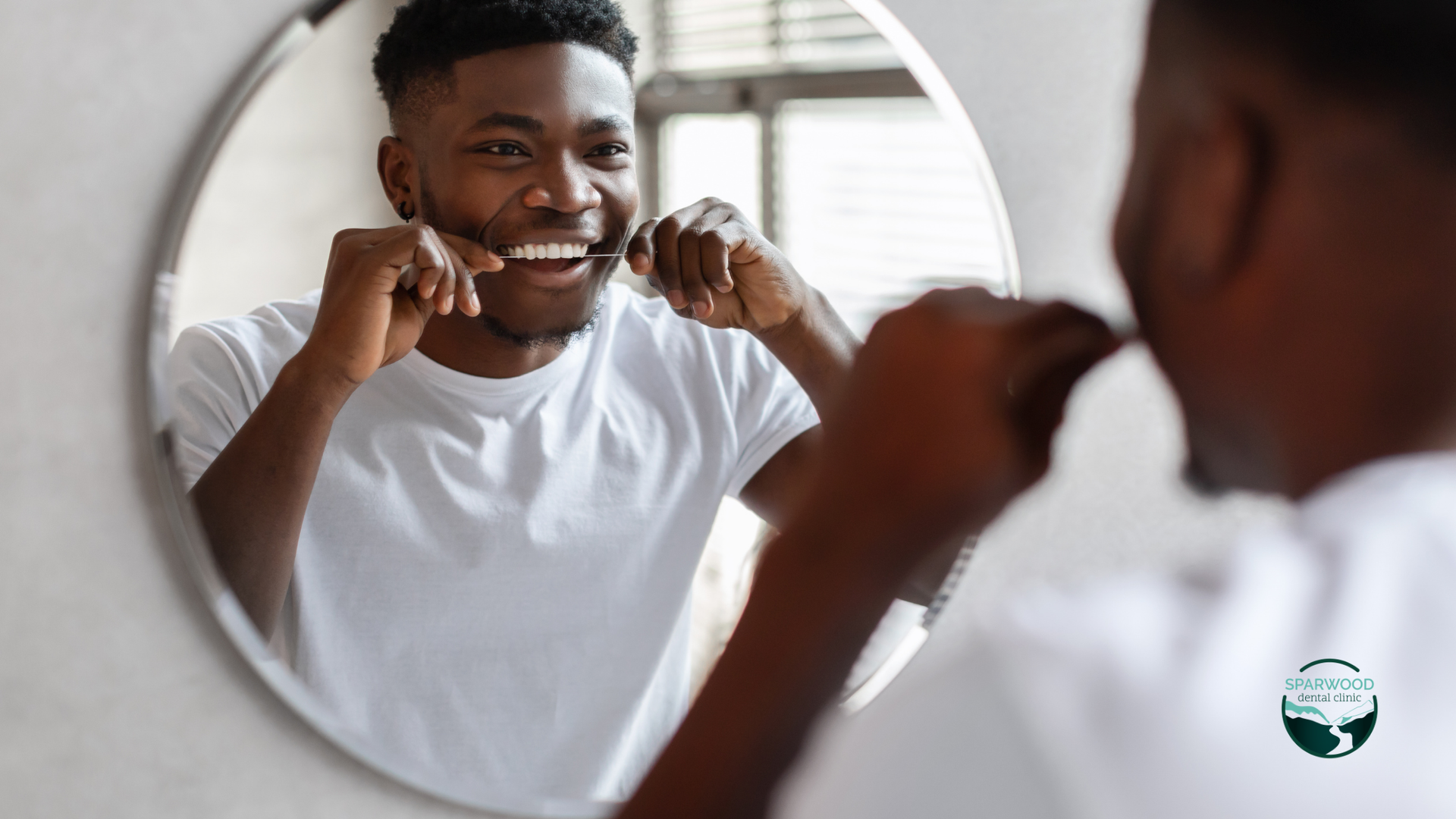 A man is brushing his teeth in front of a mirror.