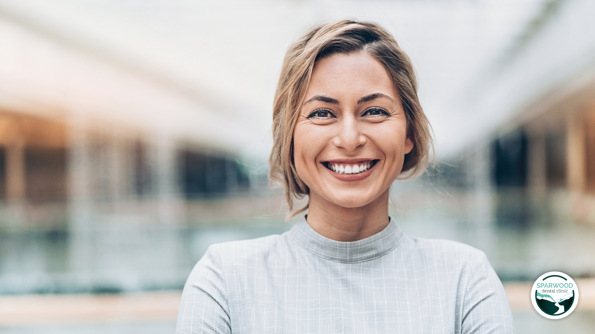 A woman is smiling for the camera with her arms crossed.