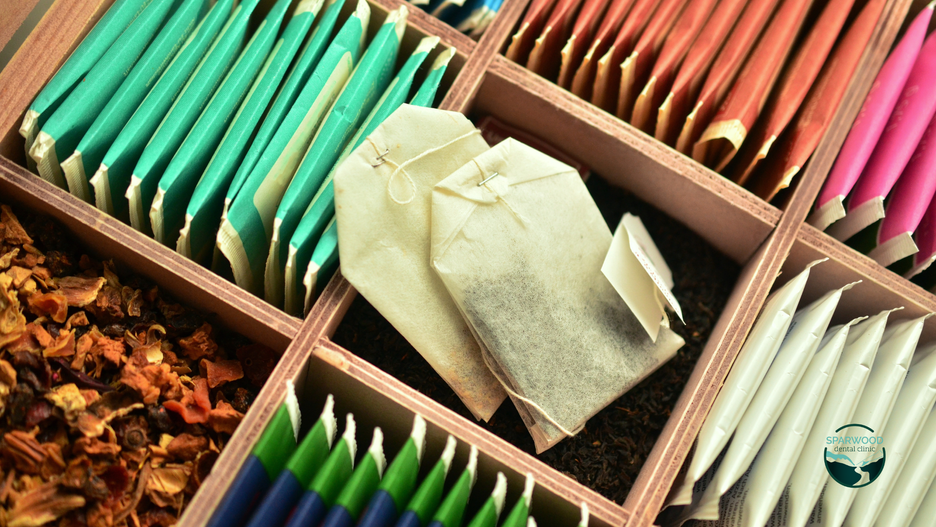 A wooden box filled with different types of tea bags