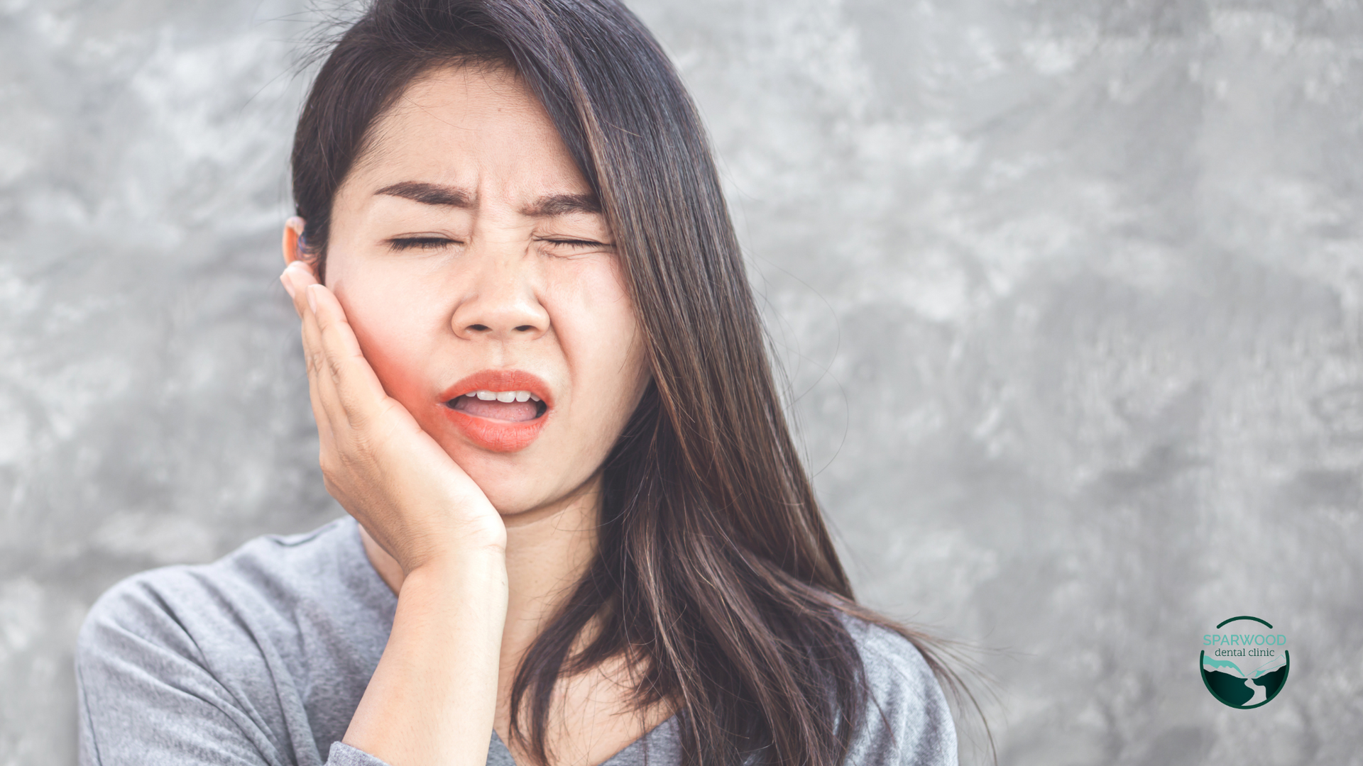 A woman is holding her face in pain because of a toothache.