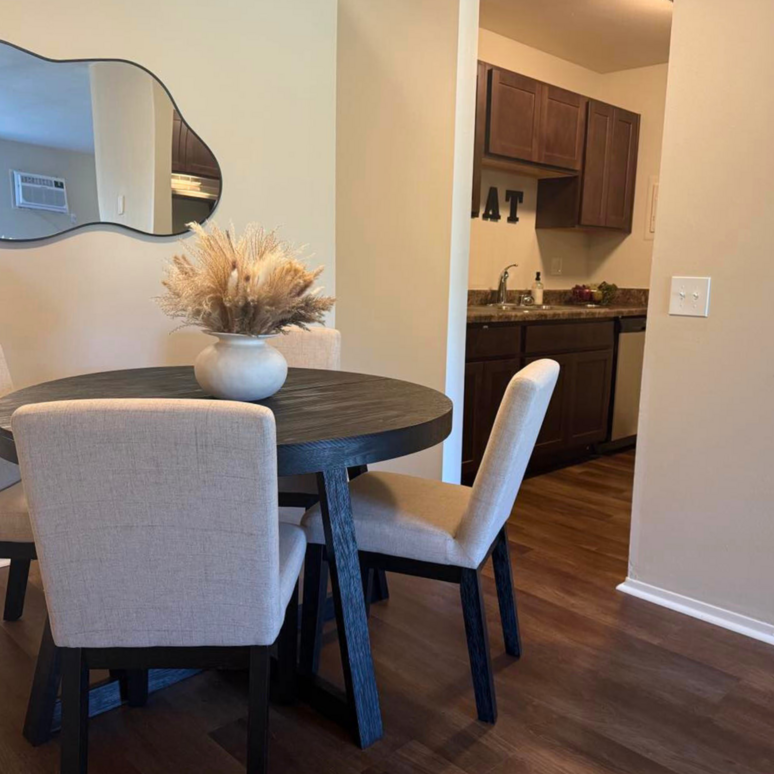 A dining room table with a vase of flowers on it