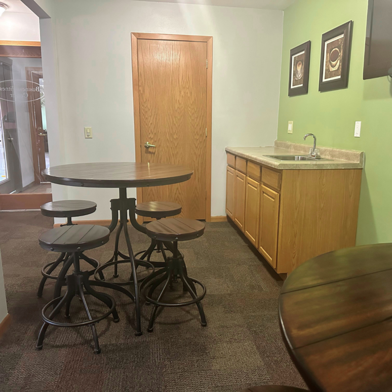 A kitchen with a table and stools and a sink