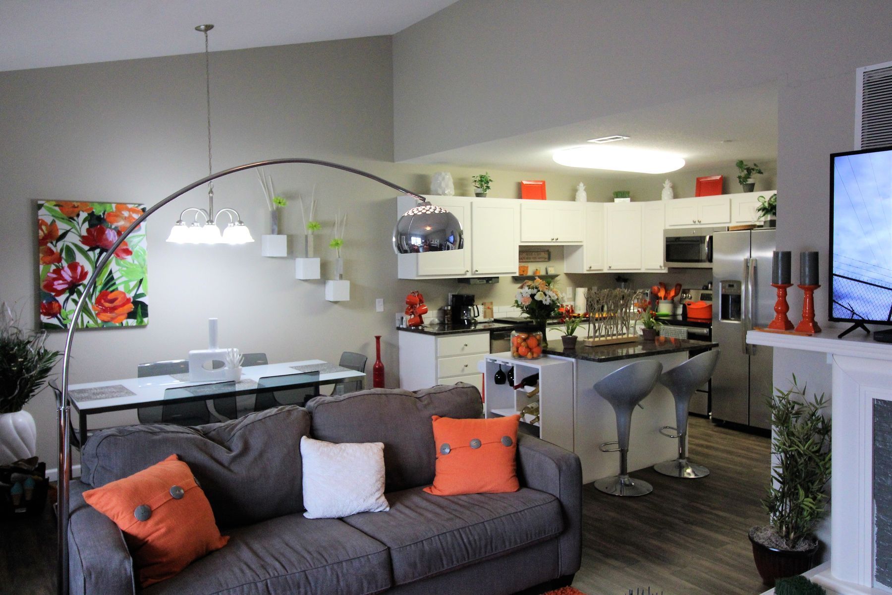 Stainless steel kitchen with white cabinets, granite counters, and a microwave above the stove.