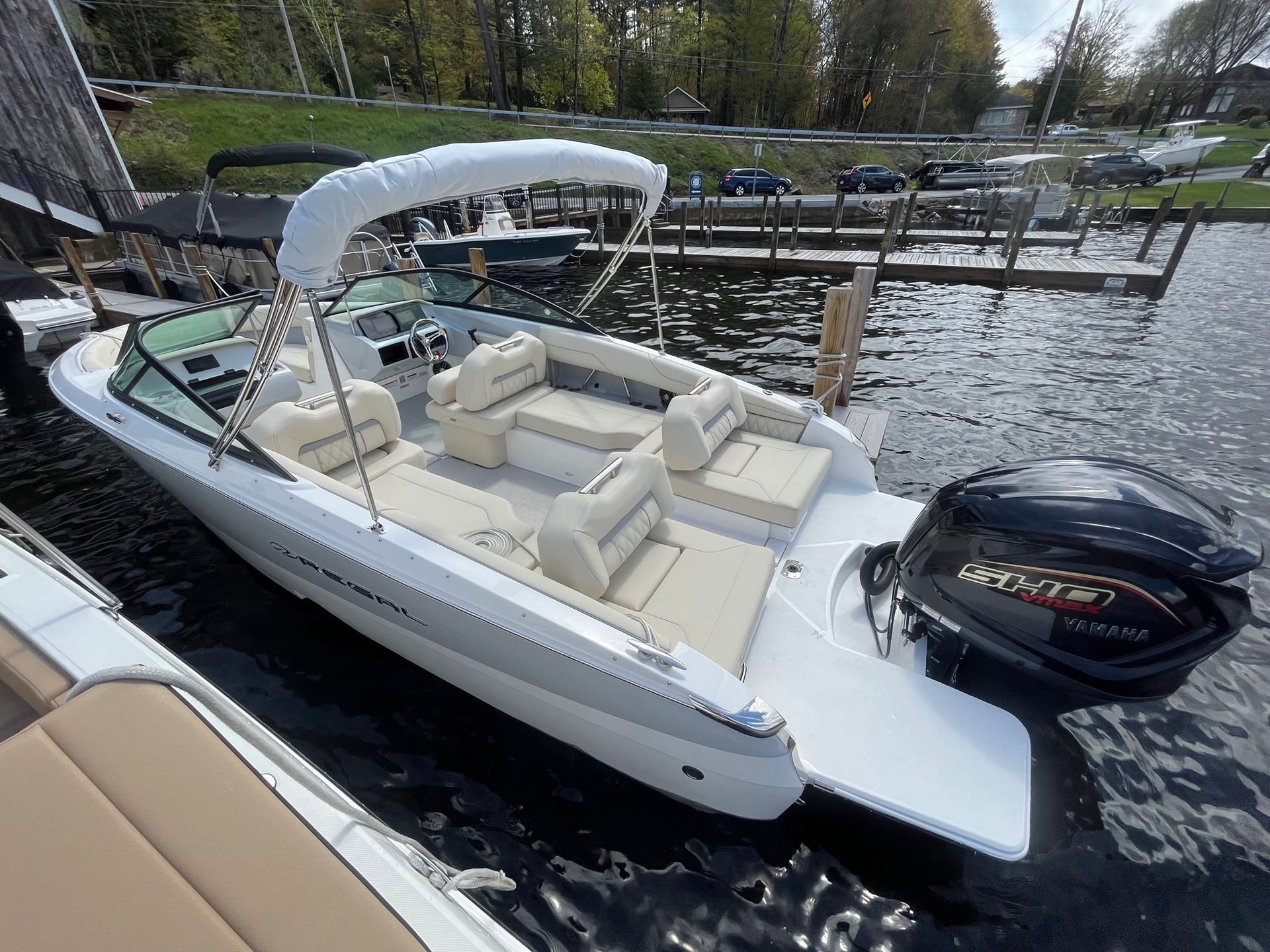 A gray boat is docked at a dock next to a body of water.