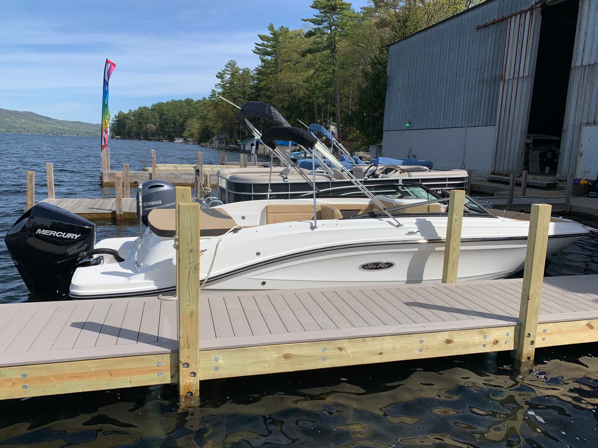 A white boat is docked at a dock next to a body of water.