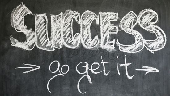 Business owner feeling stuck, sitting at a computer with hands on head.  Feeling stuck , needing guidance, needing business coaching.