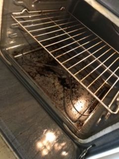 A dirty oven with a wire rack in it