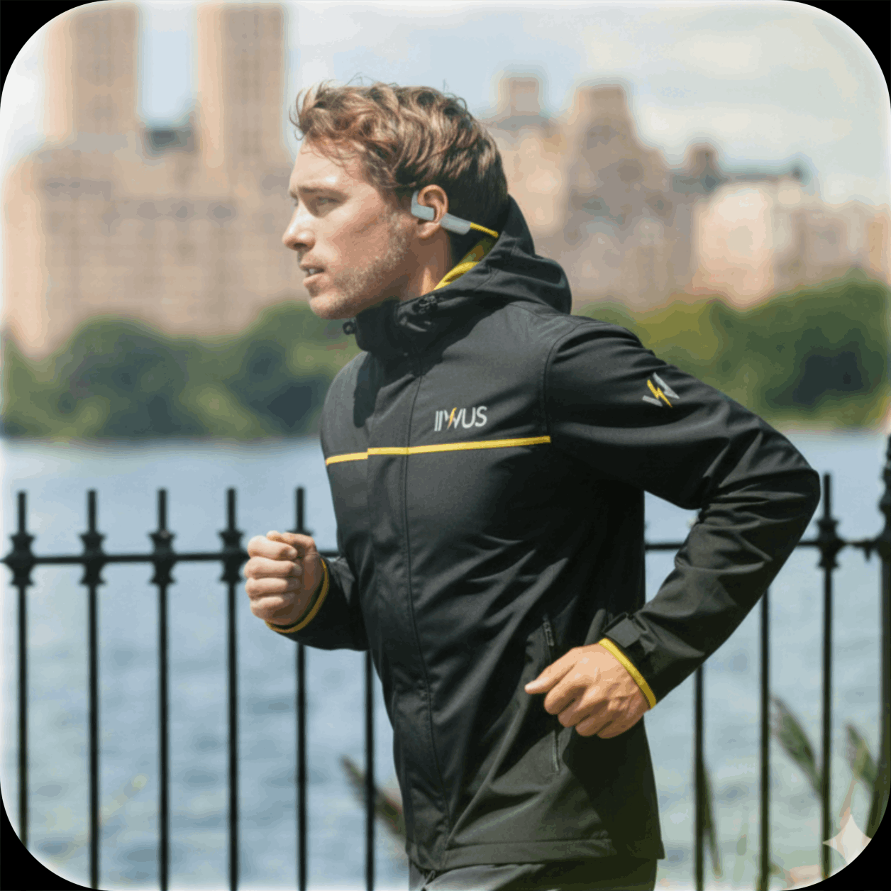Runner in a black jacket jogging beside a waterfront fence, with a city skyline in the background.