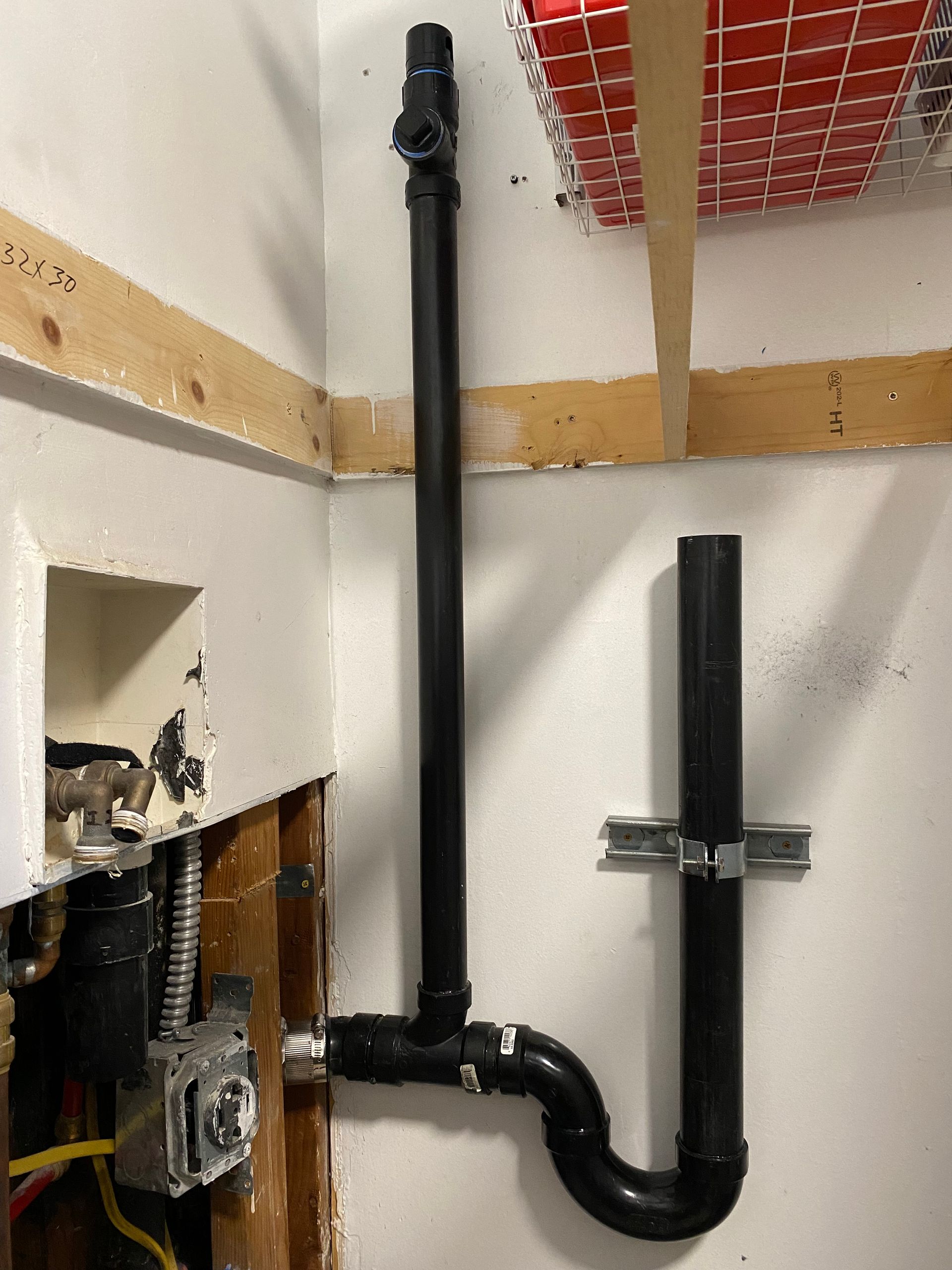 A black pipe is hanging from a wall in a room.