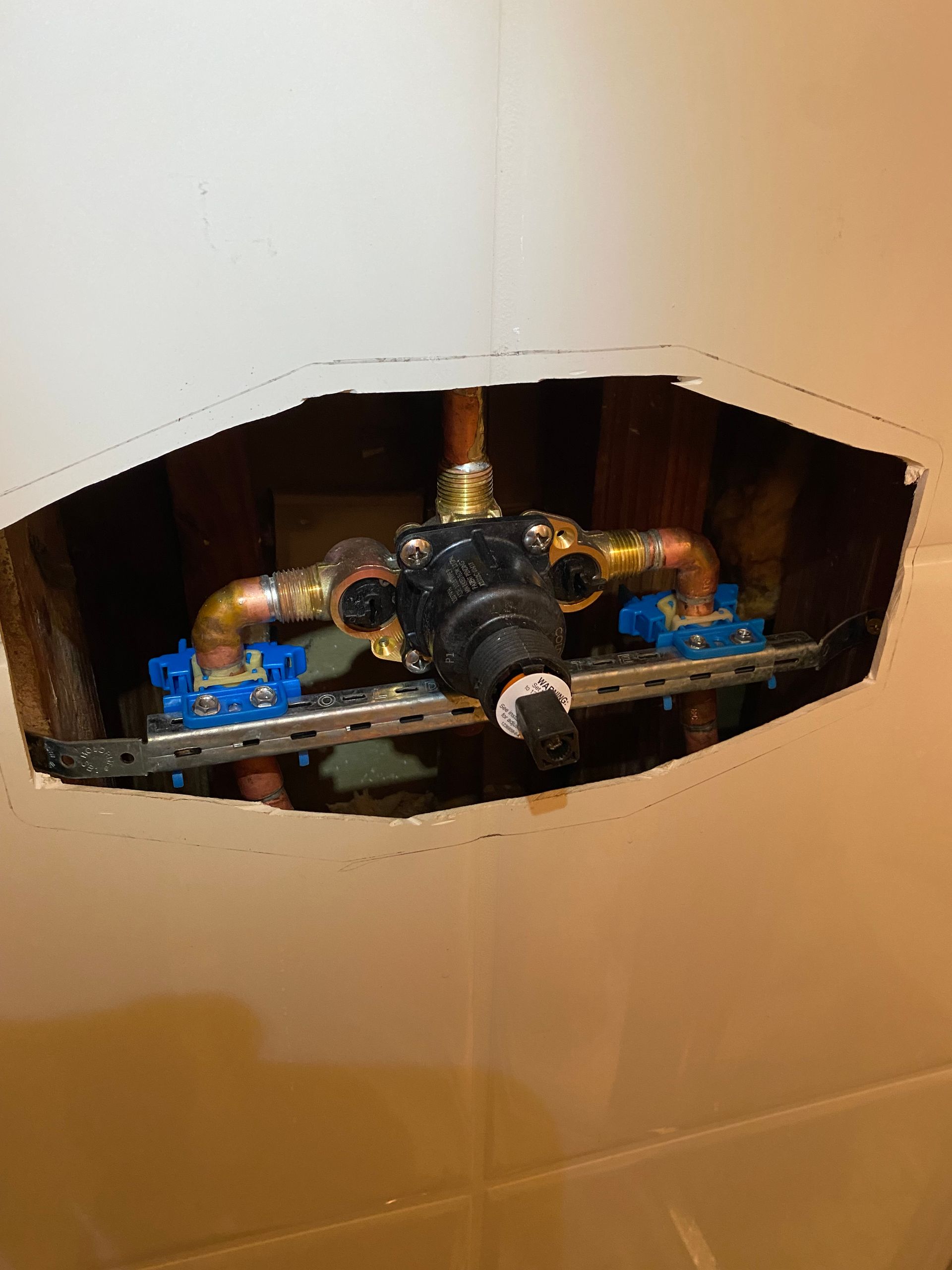 There is a hole in the wall with a faucet in it.