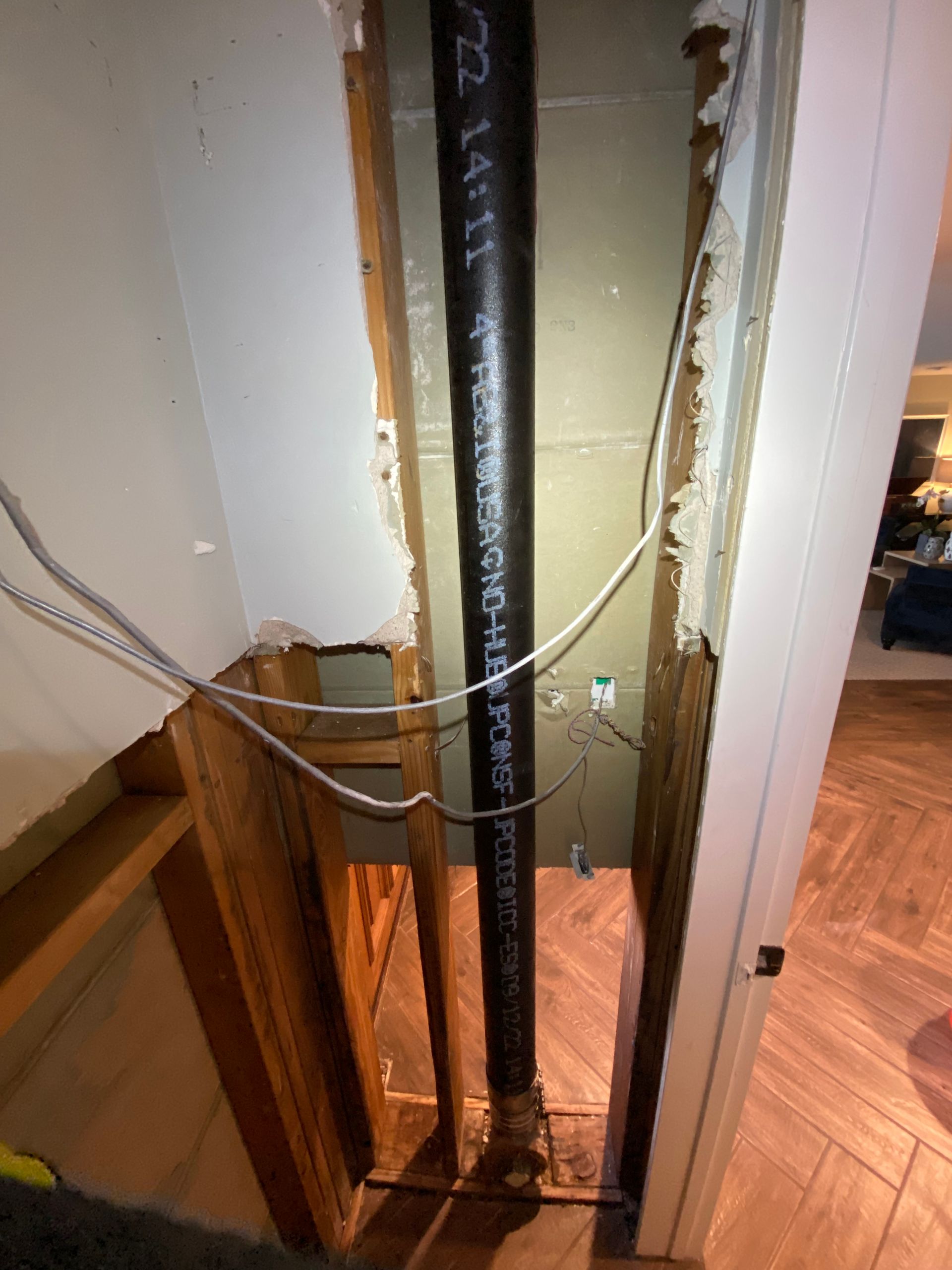 A black pipe is hanging from a wall in a room.