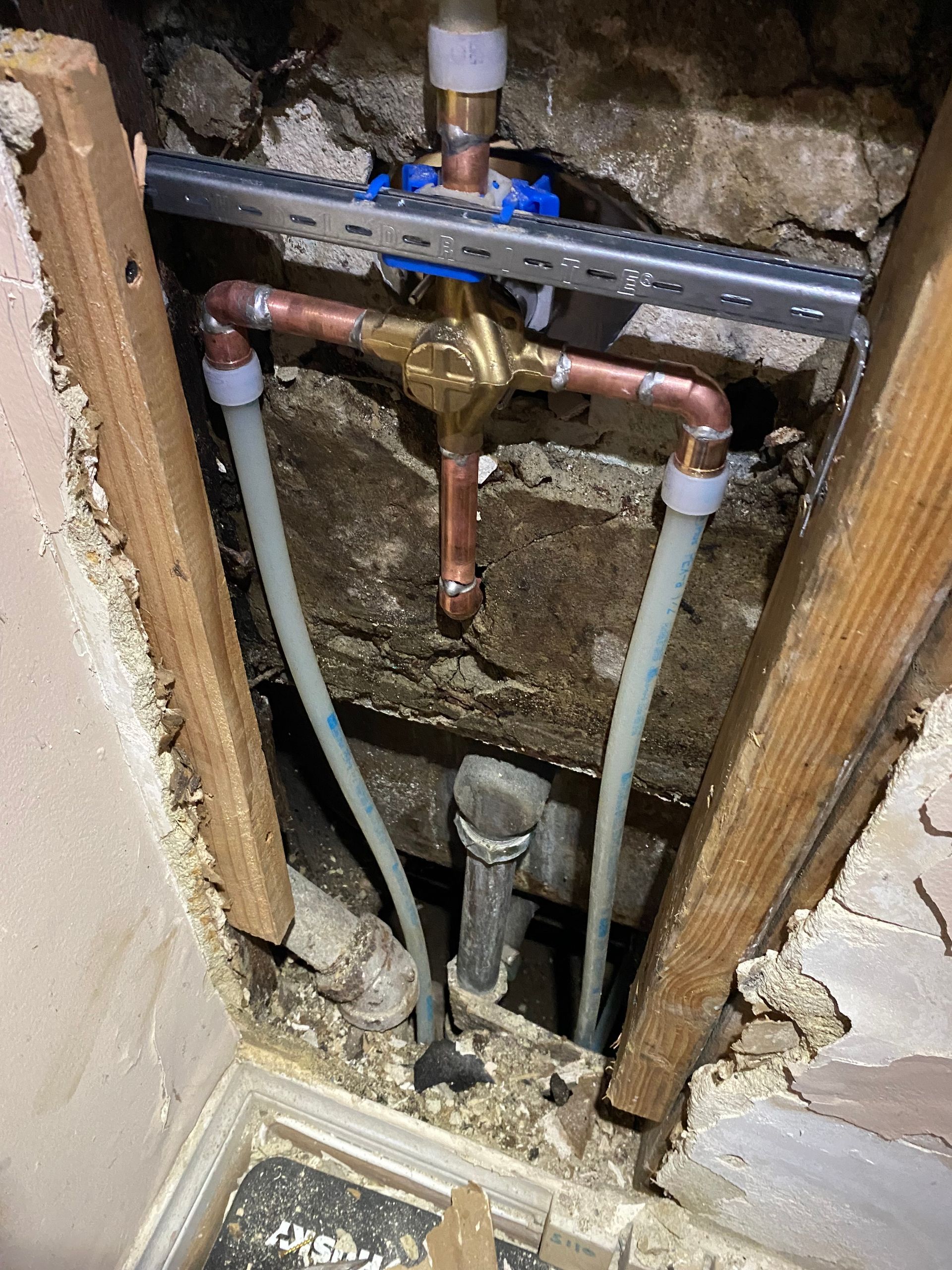 A close up of a pipe in a hole in a wall.