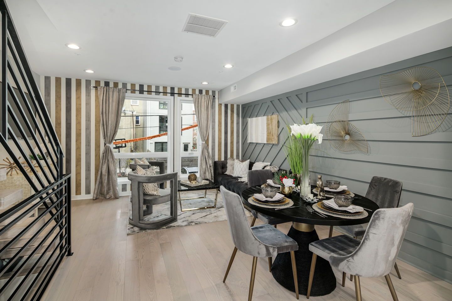 A living room with a dining table and chairs and a staircase.