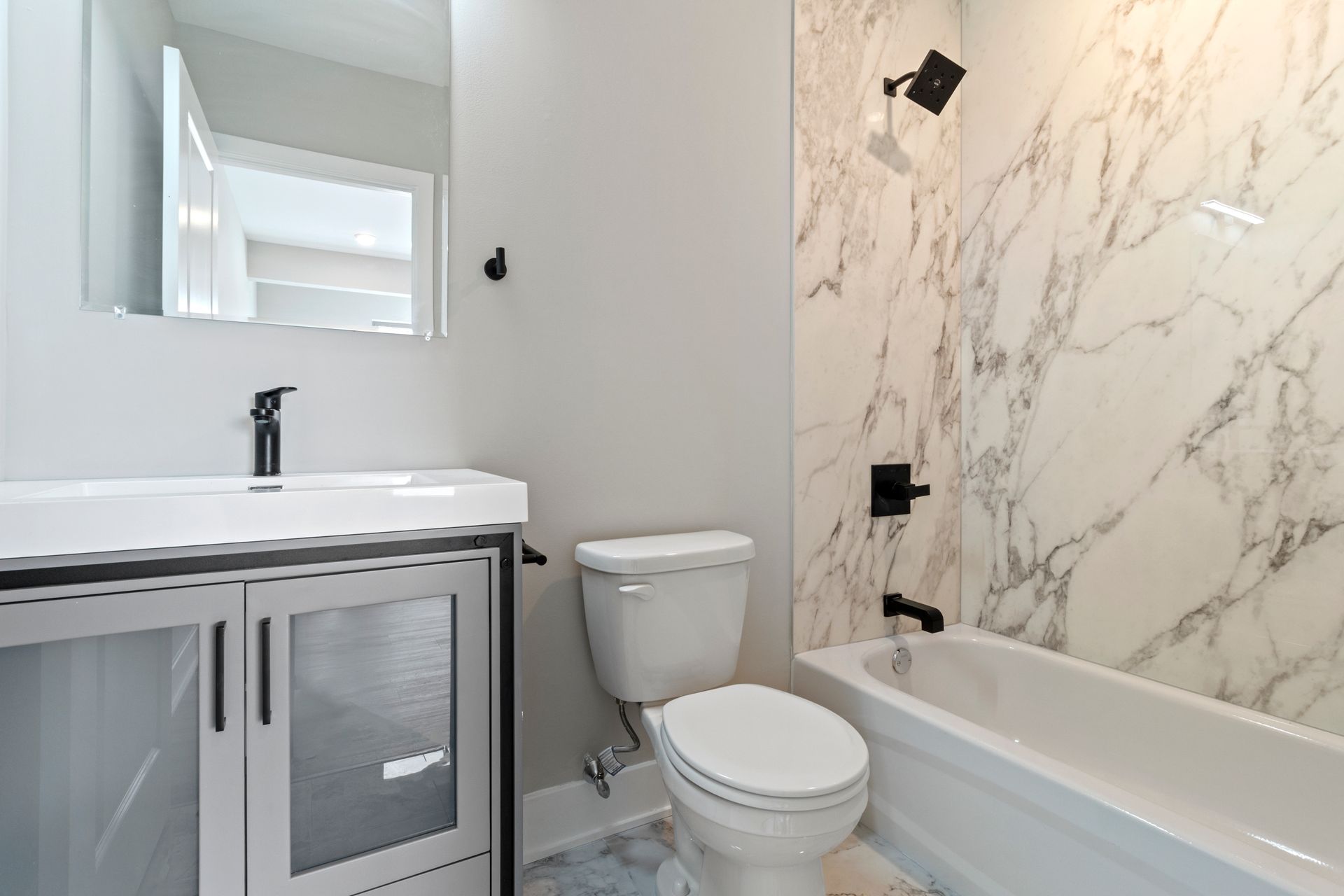 A bathroom with a toilet , sink , and bathtub.