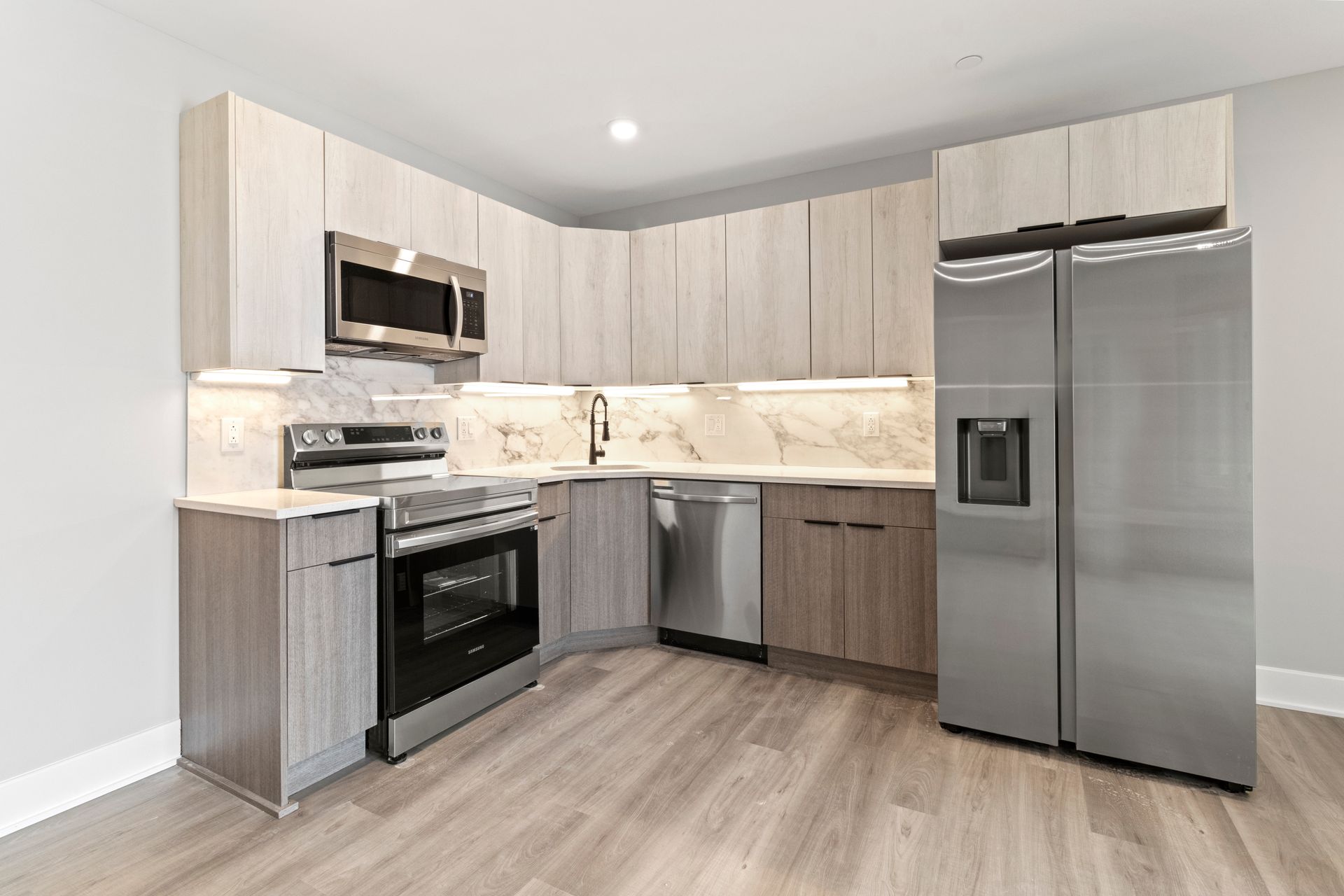 A kitchen with stainless steel appliances and wooden cabinets.