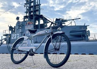 A bicycle is parked in front of a submarine.