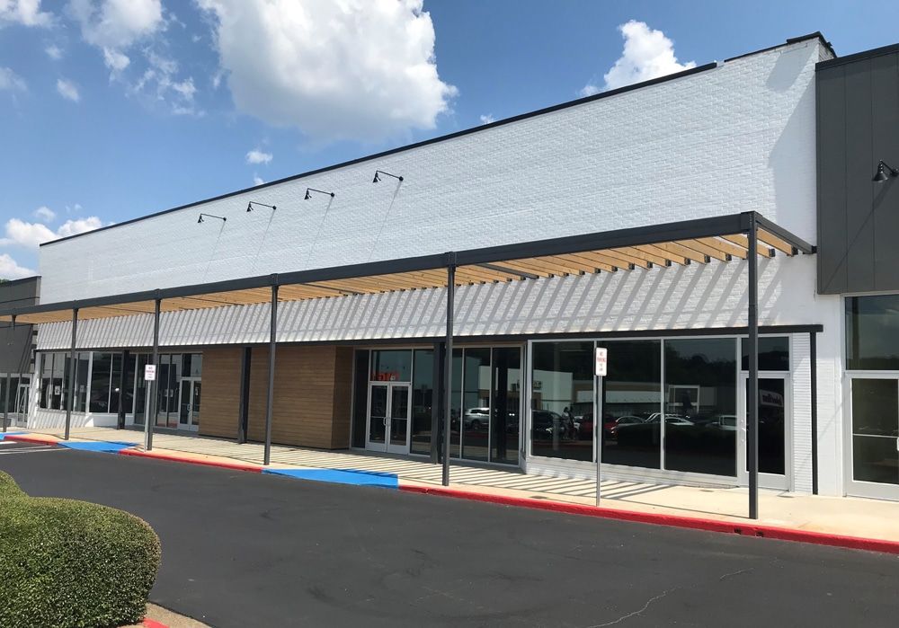 Paint roller applying black paint to a wall.