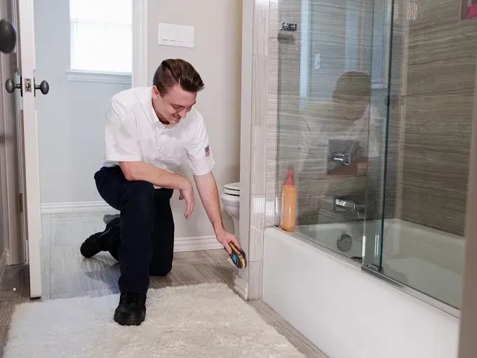 man testing mositure level on bathroom wall