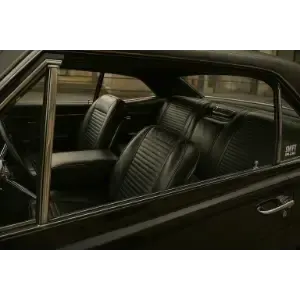 Black car interior with ribbed leather seats, viewed through the side window