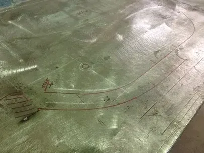 Aerial view of a wet concrete surface with circular markings and red painted lines.