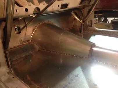 Shiny metal aircraft or vehicle interior panel with rivets and curved surfaces