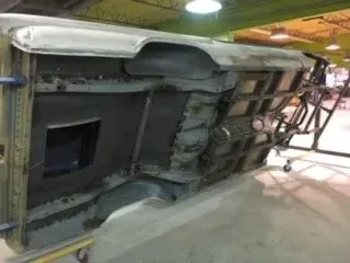 Overturned vehicle chassis with exposed underside in a garage or workshop