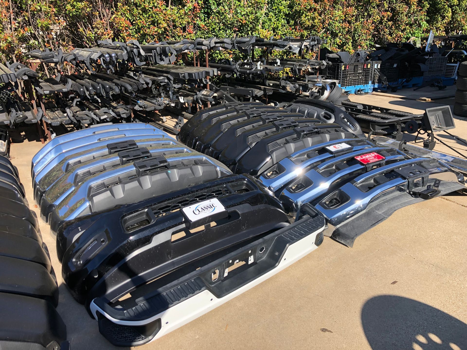 A bunch of jeep bumpers are stacked on top of each other.