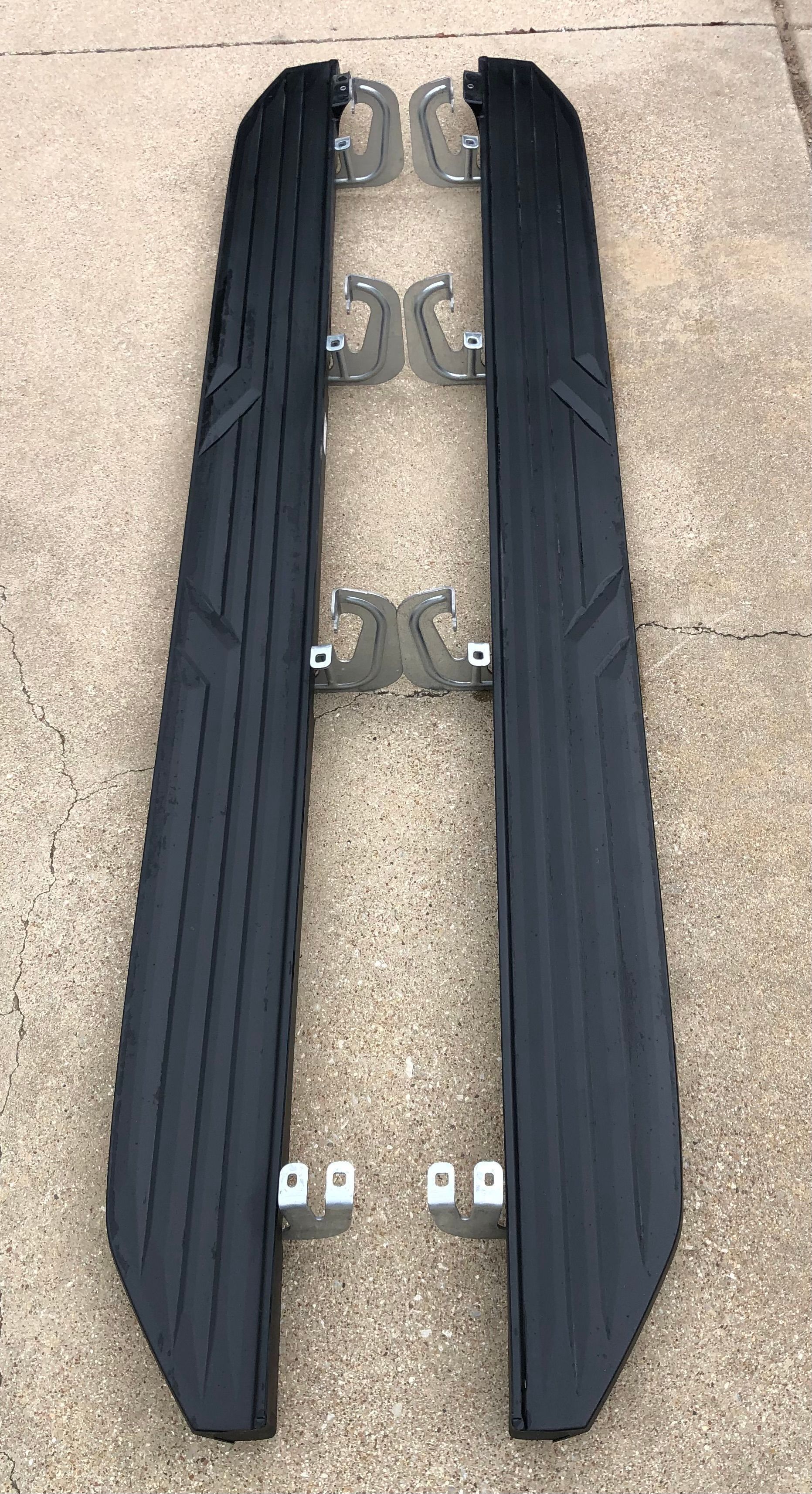 A pair of black side steps sitting on top of a concrete surface.