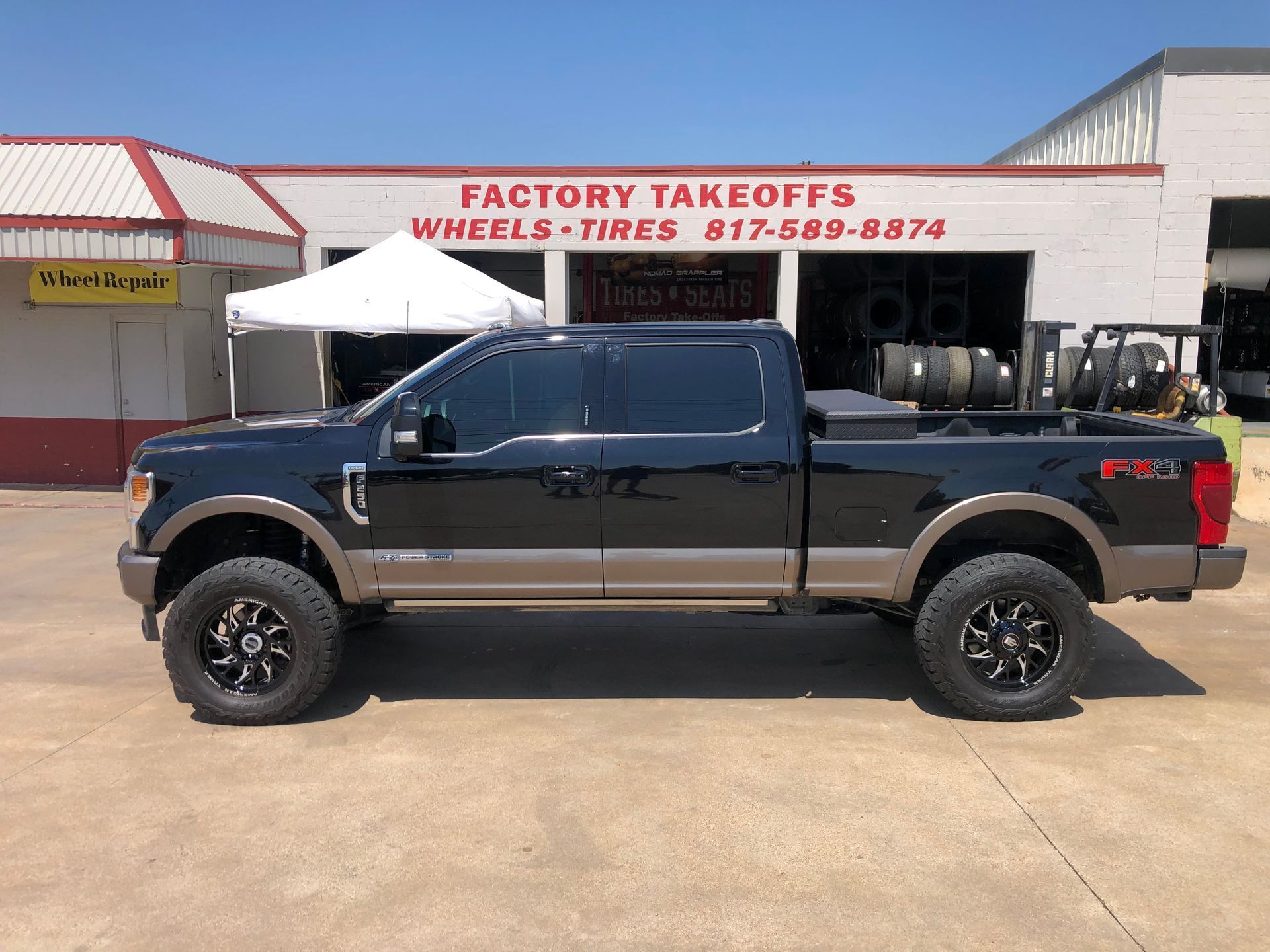 A black pickup truck is parked in front of a building.