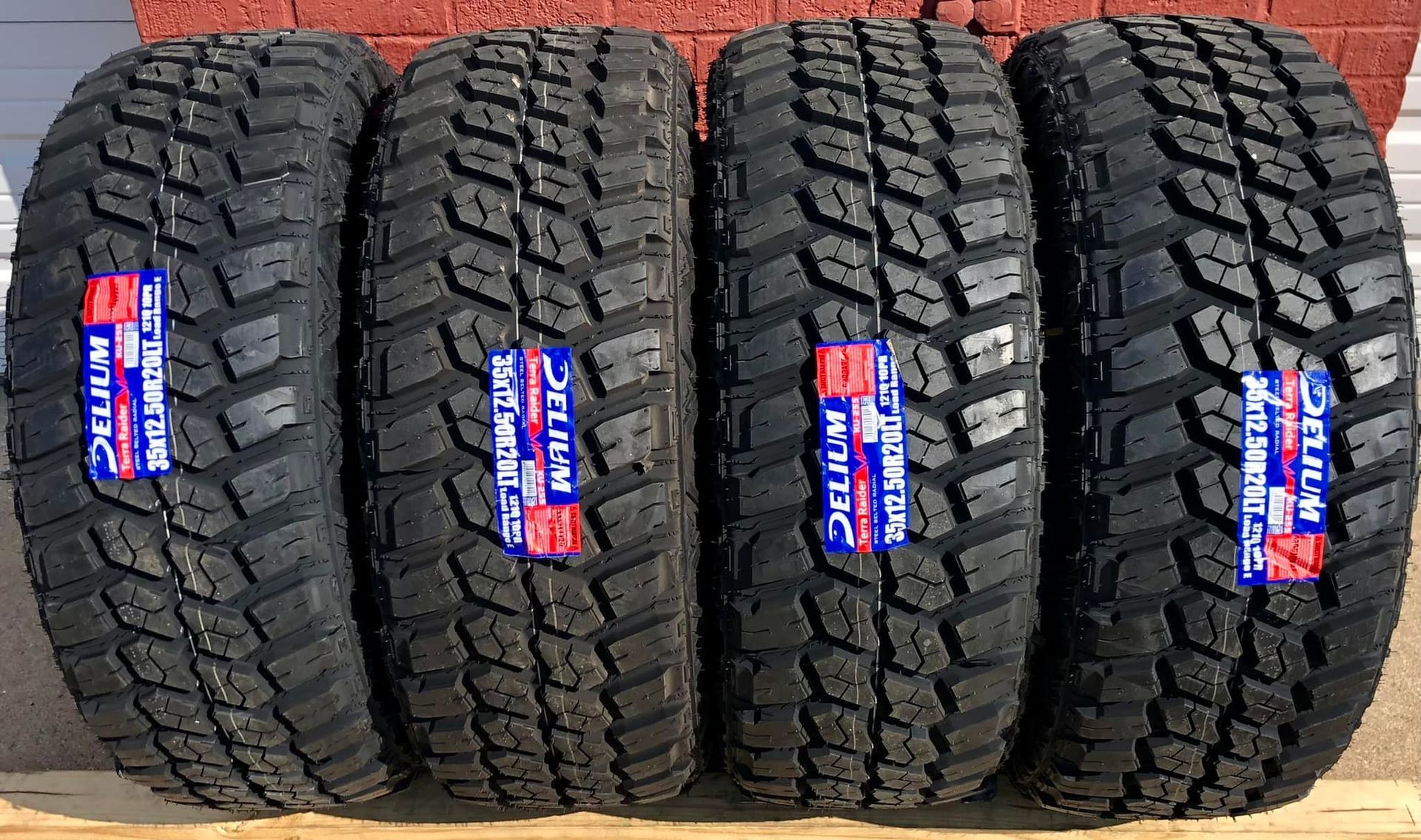 Four tires are stacked on top of each other on a wooden table.
