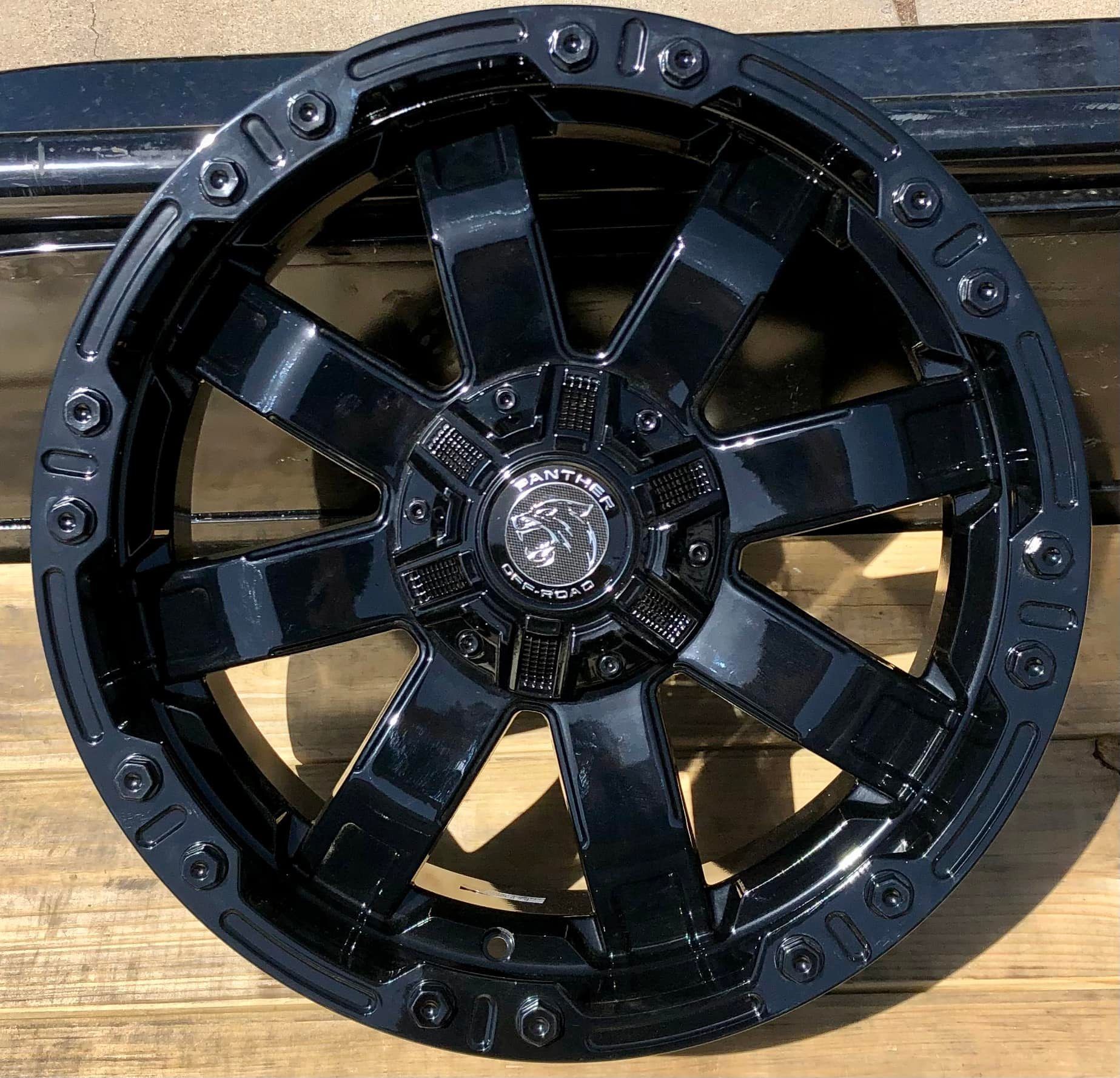 A black wheel is sitting on a wooden table.