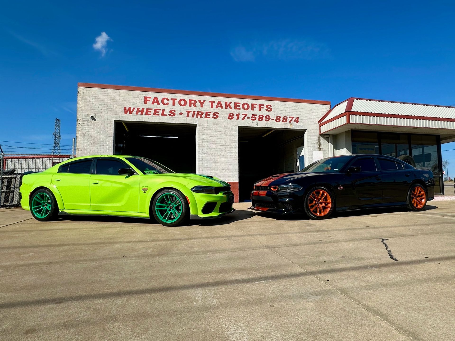 Two cars are parked in front of a garage.