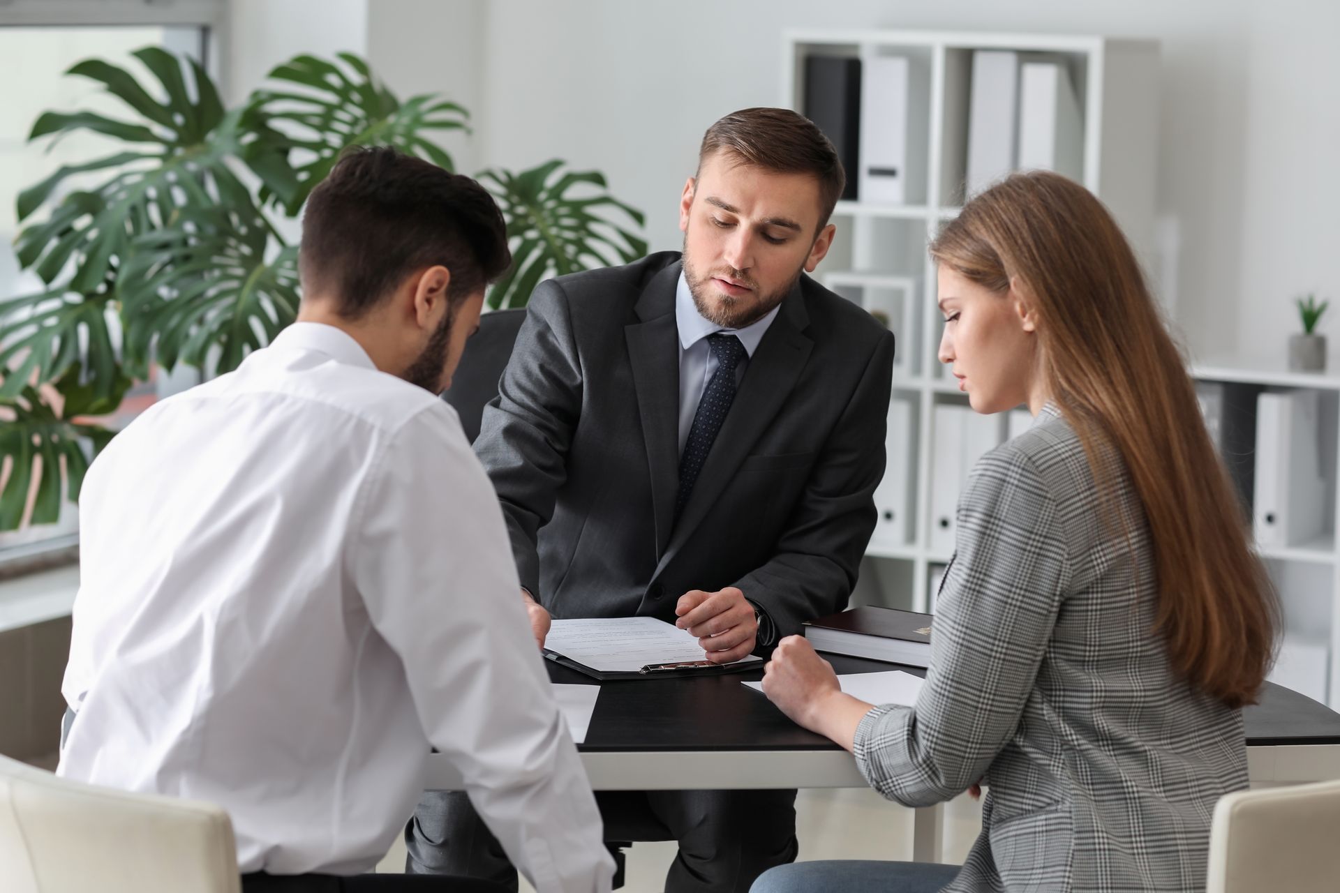 A couple is reviewing a document in front of a lawyer.