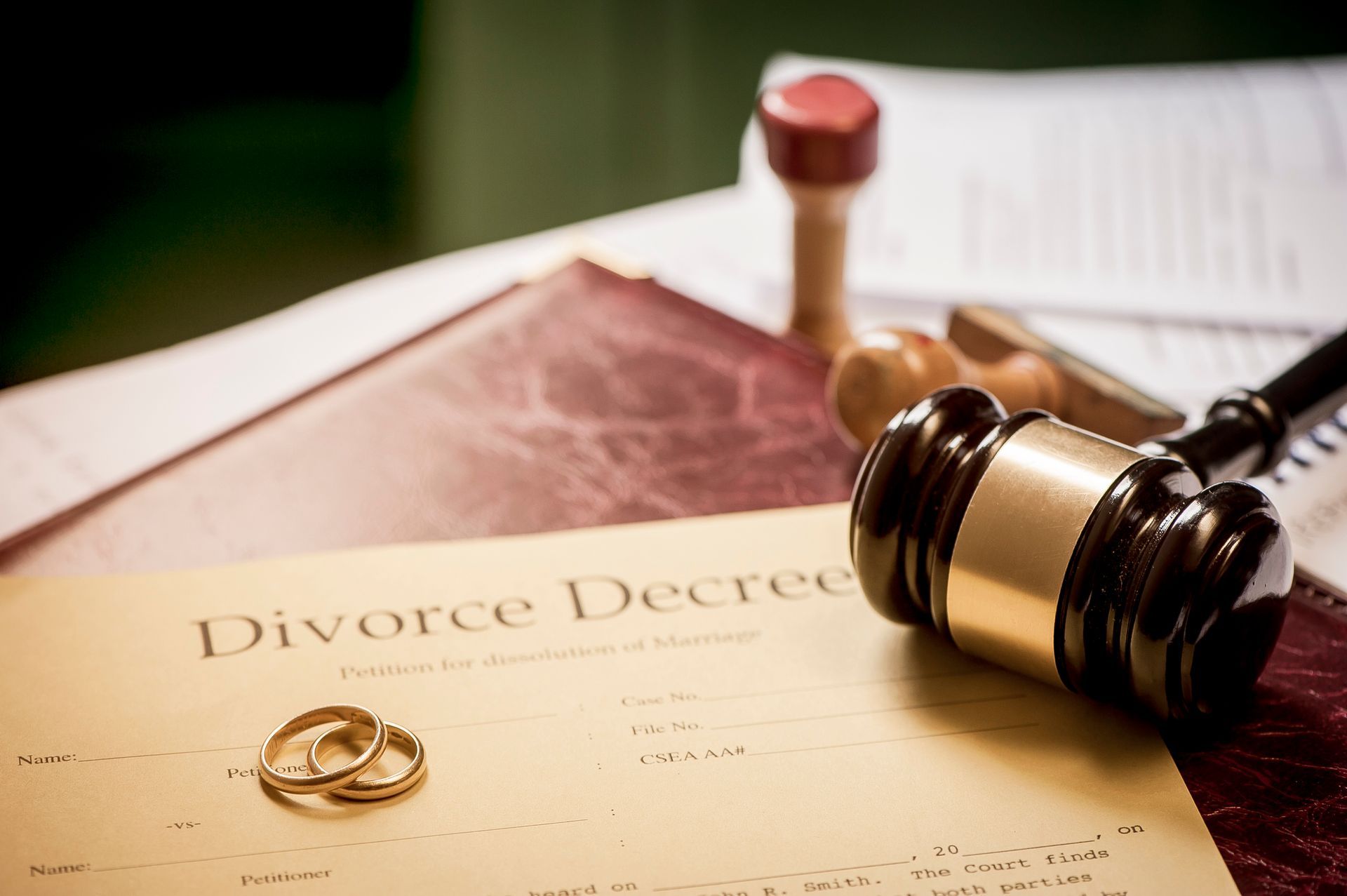 A divorce decree and wedding rings together on a table, representing divorce attorneys.