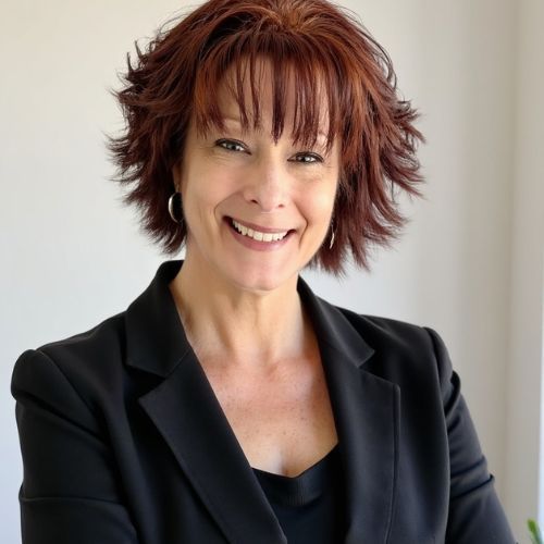 A woman with red hair is smiling for the camera