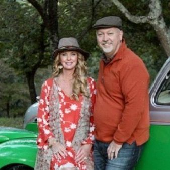 A man and a woman are standing next to a green car.