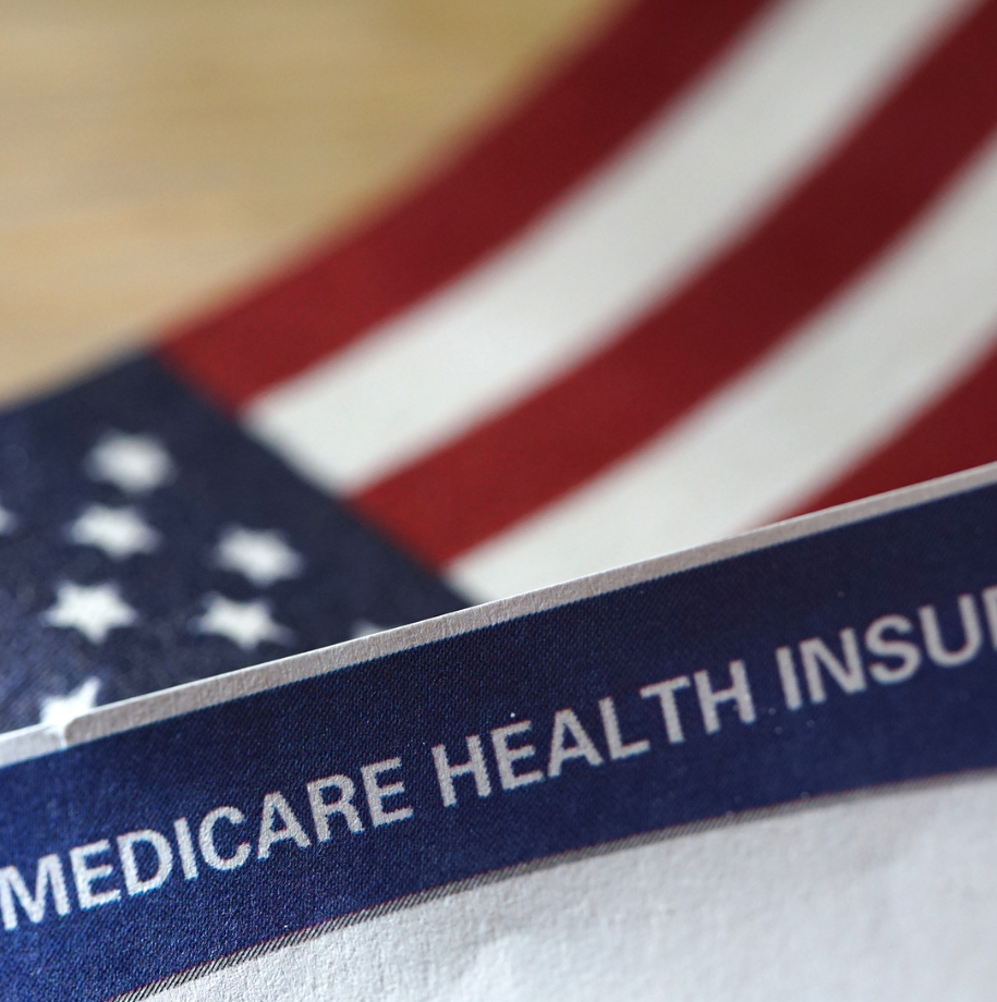 An american flag is behind a medicare health insurance card