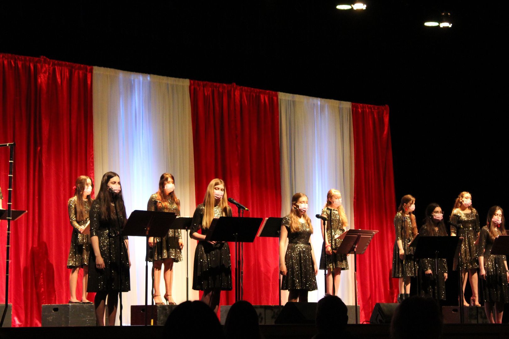 A group of young girls are singing on a stage.