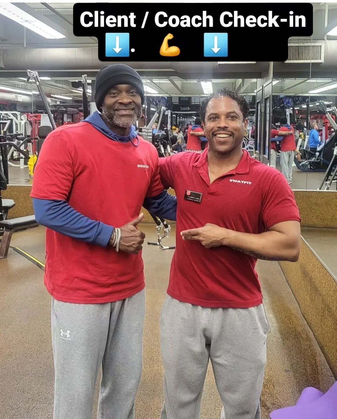 Two men in red shirts at a gym, one points at the other. Text above: 