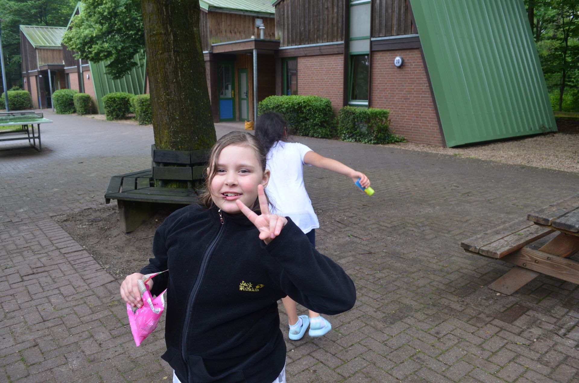 Ein Mädchen in einer Jack Wolfskin-Jacke macht ein Peace-Zeichen - Karate-Jugendfreizeit.