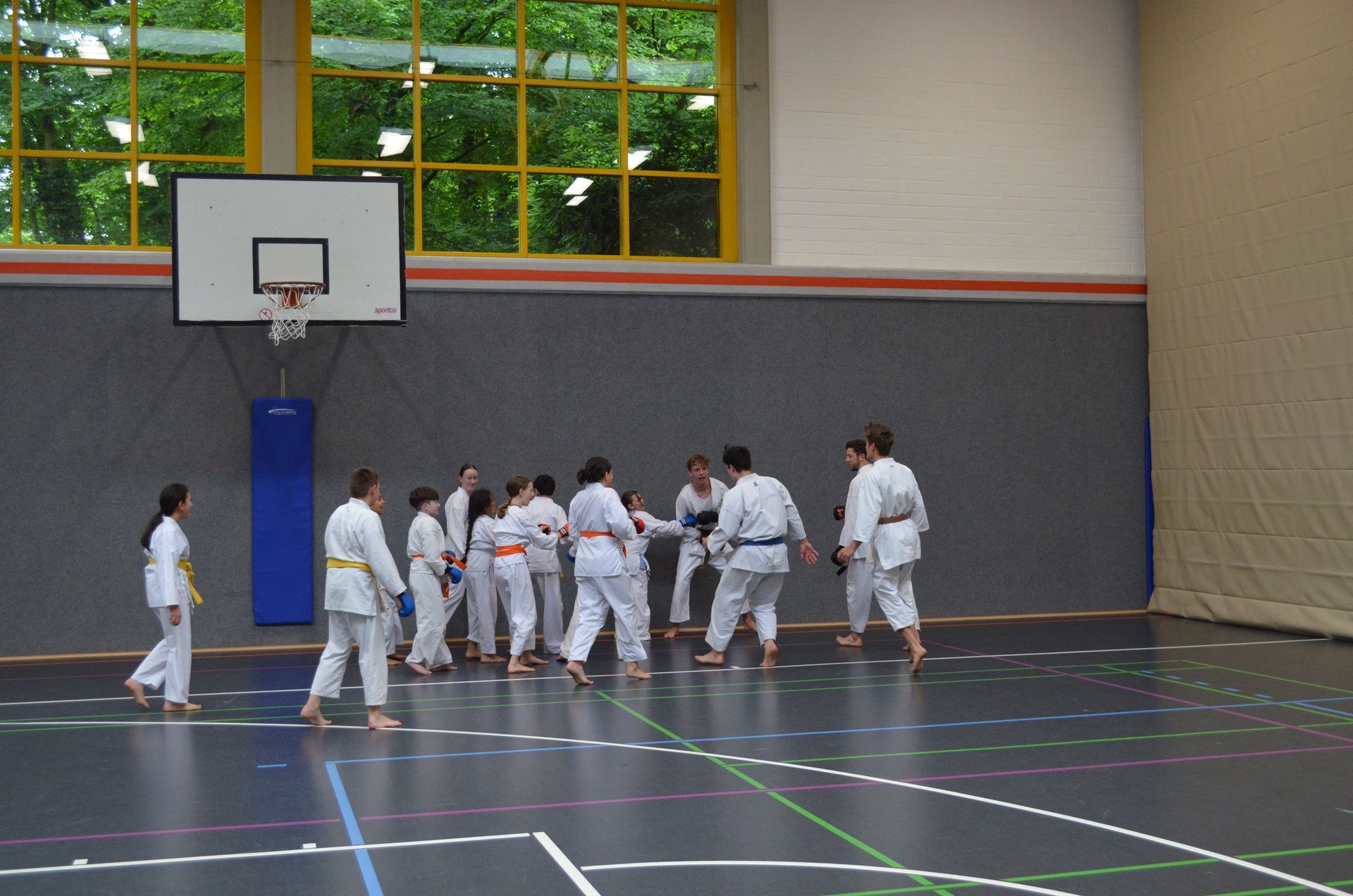 Eine Gruppe von Menschen praktiziert Kampfsport in einem Fitnessstudio - Karate-Jugendfreizeit.