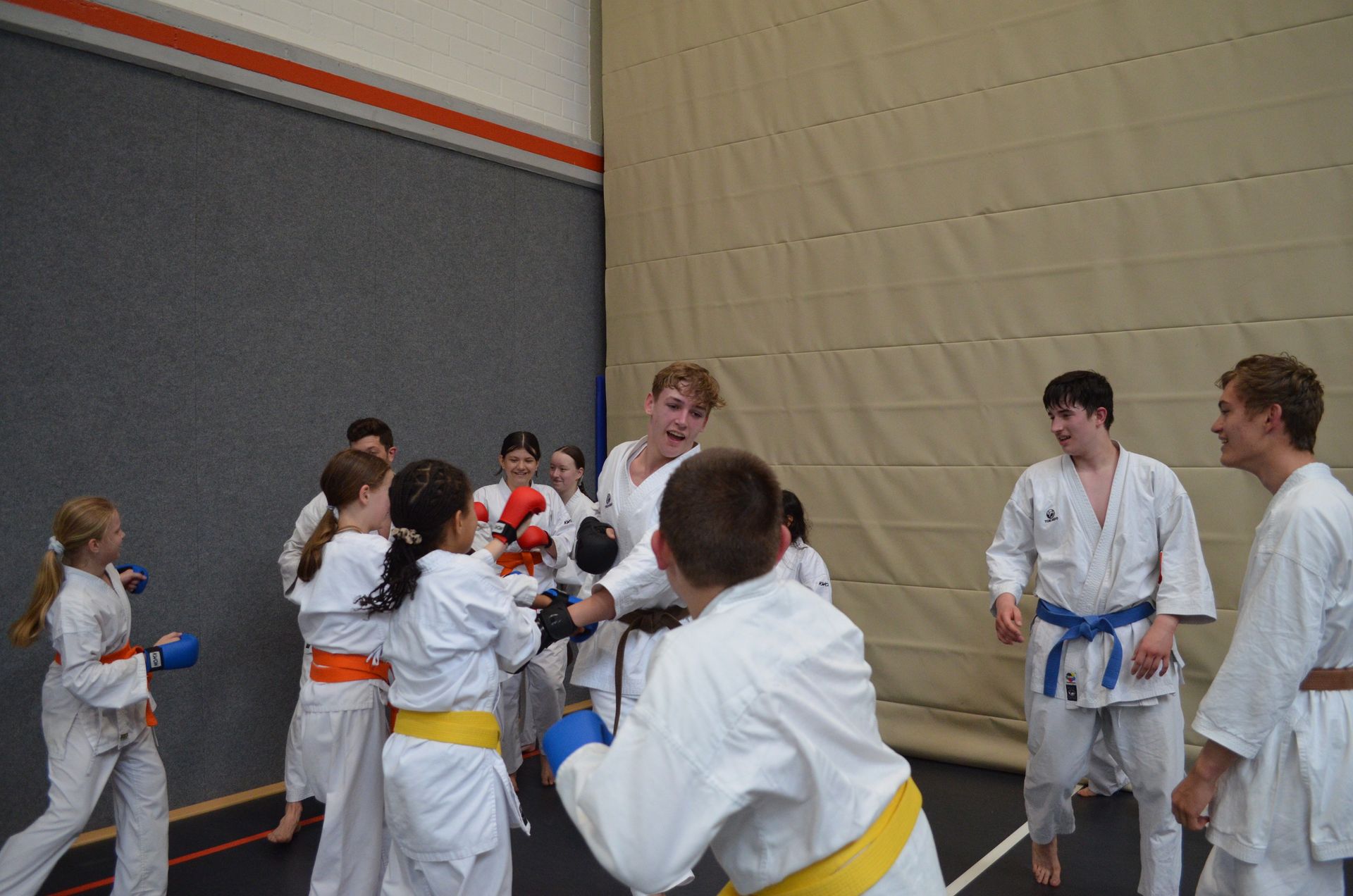 Eine Gruppe junger Leute übt in einem Fitnessstudio Kampfsport - Karate-Jugendfreizeit.