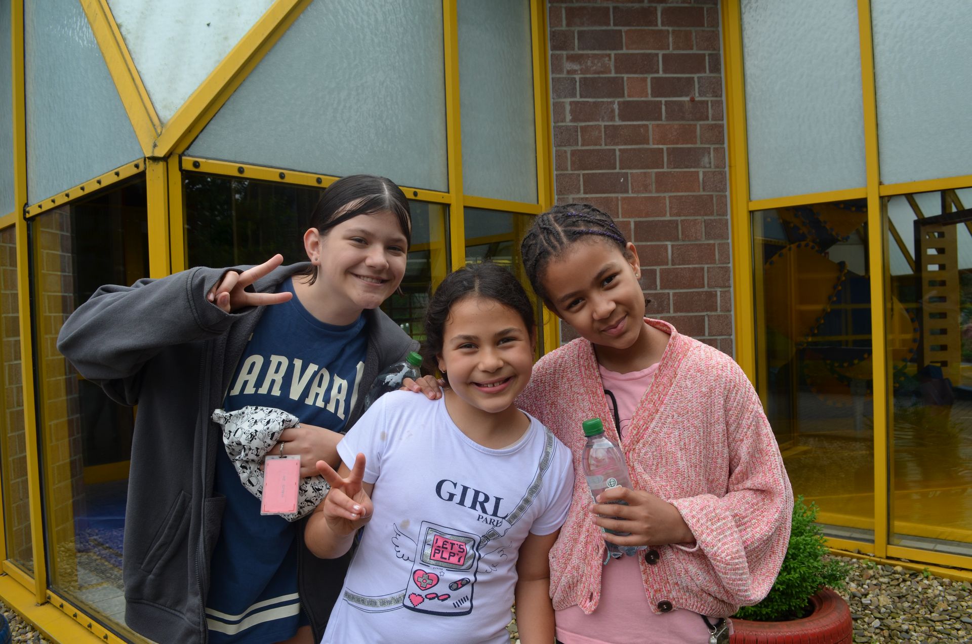 Drei junge Mädchen posieren vor einem Gebäude für ein Foto - Karate-Jugendfreizeit.